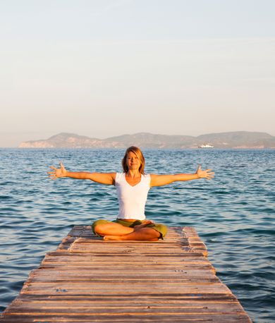 Femme sur un ponton devant la mer